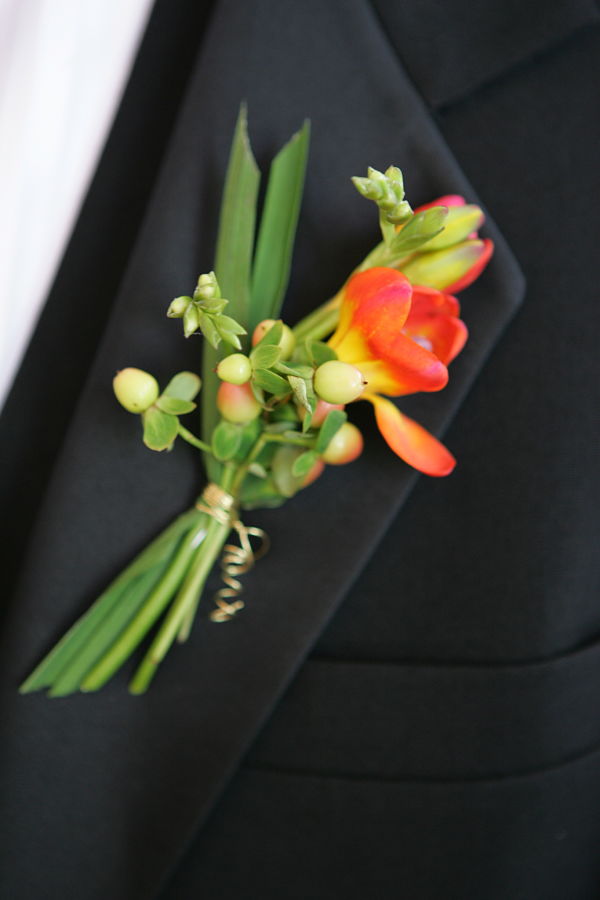 Bold Colorful Orange Freesia Boutonniere With Peach Hypericum Berry
